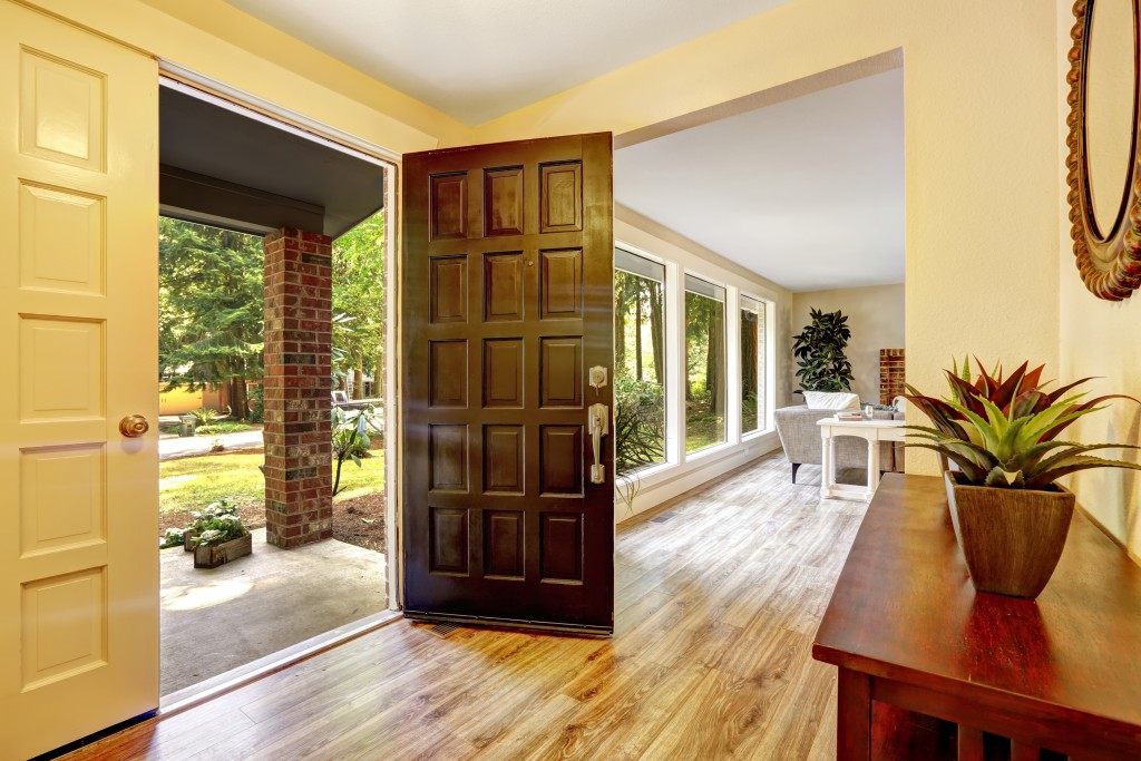 Entrance hallway with cabinet. View of entrance porch through open door