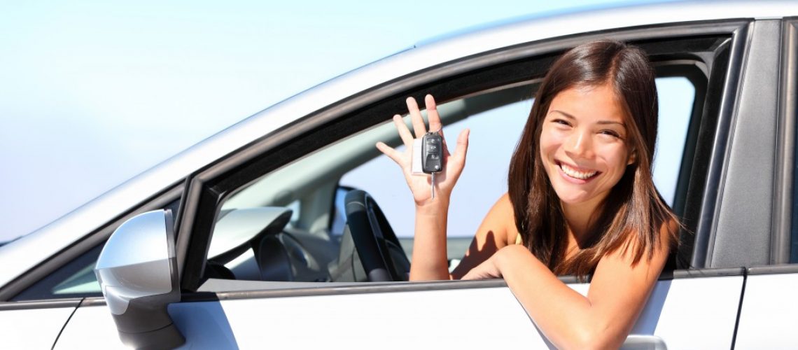 woman holding a car key inside the car